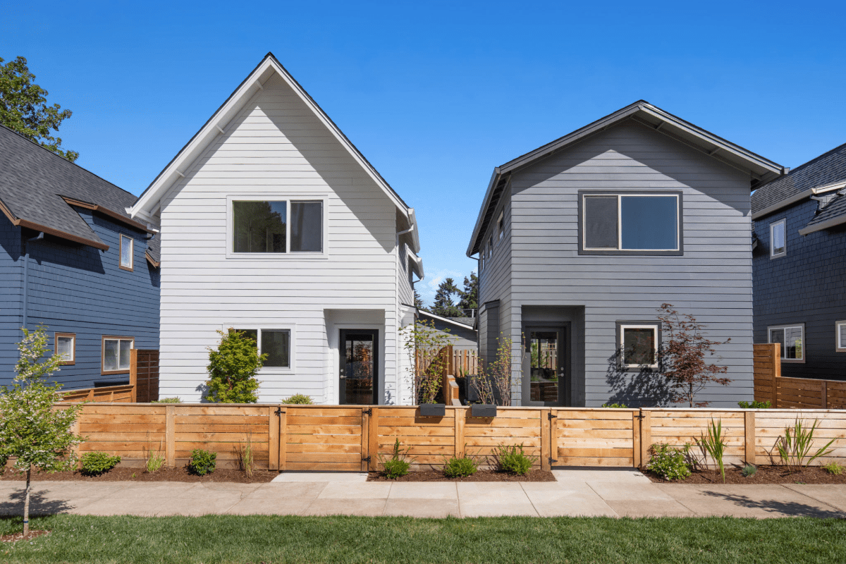 Two modern houses with wooden fences.